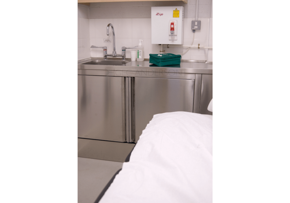 Stainless steel first aid room worktop with stainless steel base cabinets and plinth