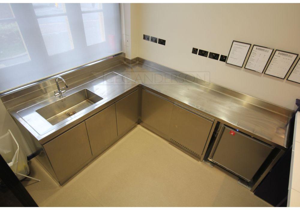 Stainless steel worktop formed in one piece with integral sink and back upstands.