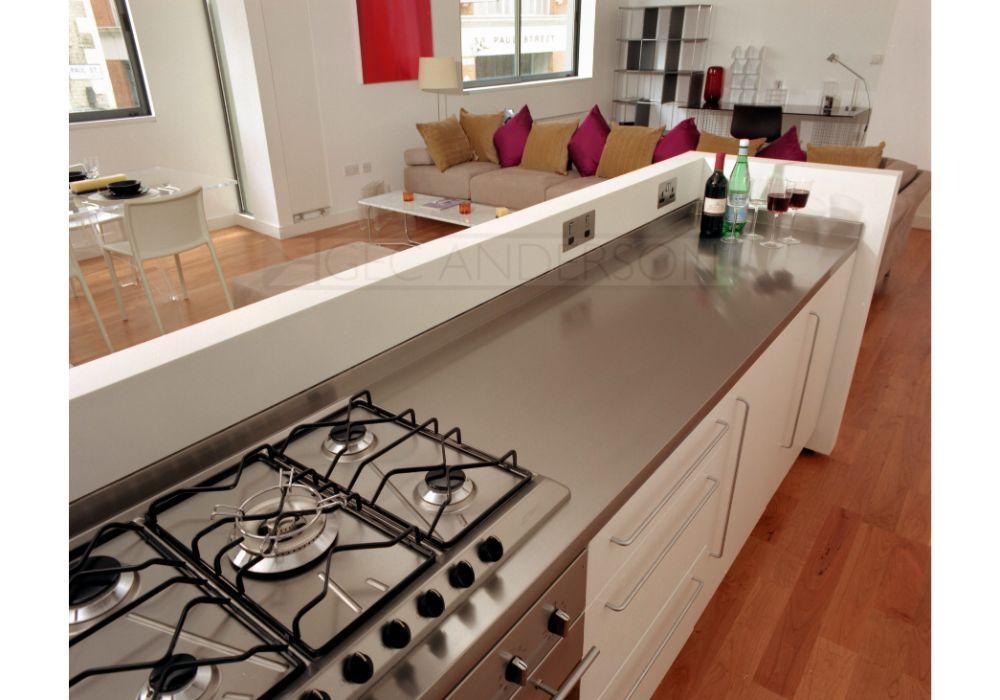 Continuous stainless steel worktop with integral back and side upstands. Hob cutout.