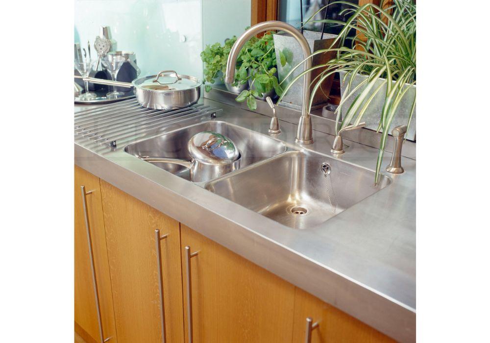 Stainless steel worktops with deep front edge profile and integrated sinks.